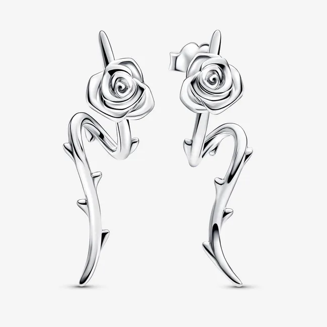 Silver earrings shaped like roses with stems and thorns, set against a plain background.